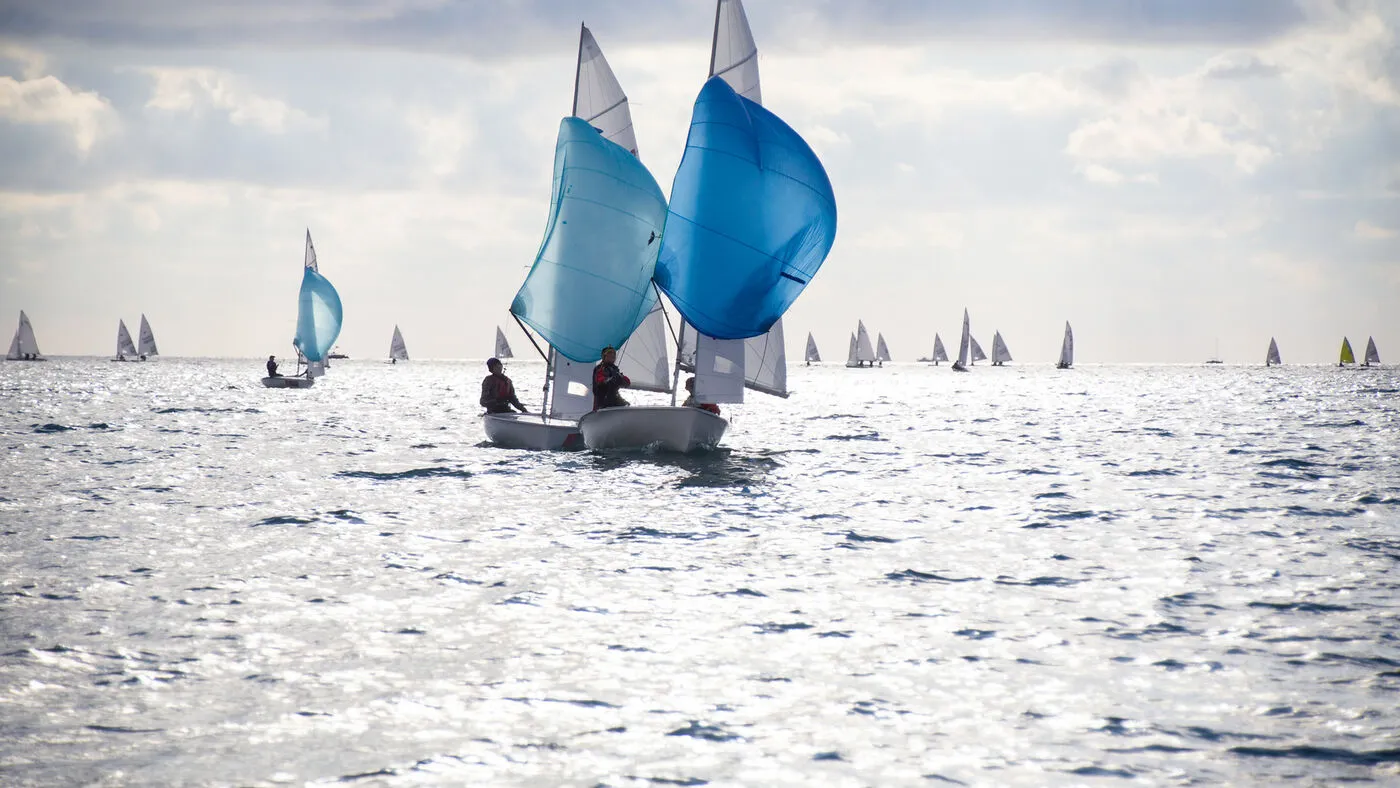 Segelboote mit blauen Segeln auf dem offenen Meer.